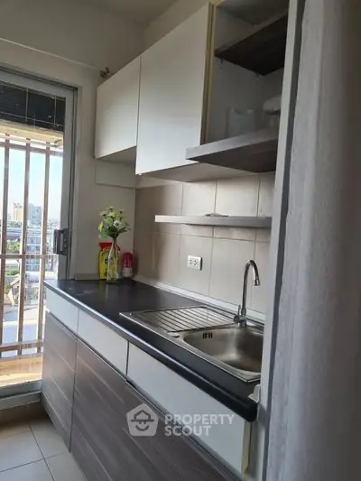 Modern kitchen with sleek cabinetry and city view from window