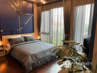 Luxurious bedroom with modern decor and large windows offering natural light and city views.