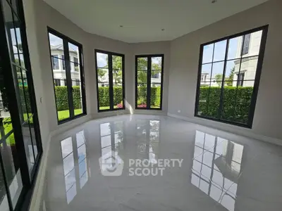 Spacious room with large windows offering a stunning garden view in a modern home.
