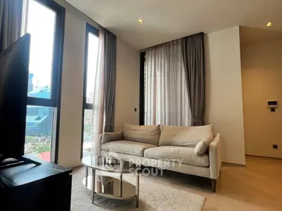 Modern living room with large windows and cozy sofa in a high-rise apartment.