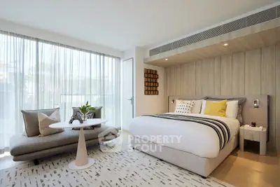 Luxurious modern bedroom with stylish decor and large windows offering natural light