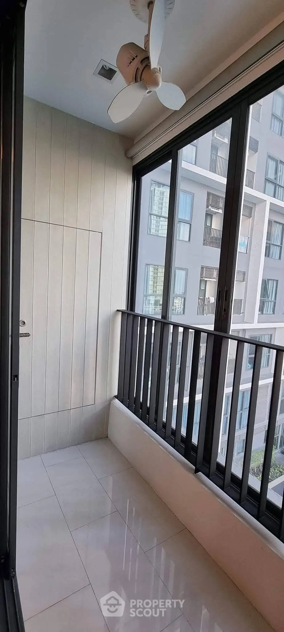 Modern balcony with sleek railing and city view in a contemporary apartment building.
