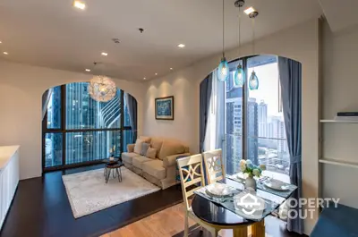 Elegant high-rise corner unit with expansive windows offering a panoramic city view, featuring a cozy living space with modern furnishings and chic pendant lighting.