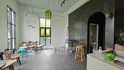 Spacious room with modern decor and large windows, ideal for versatile use.