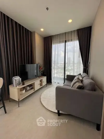 Modern living room with city view, featuring sleek furniture and floor-to-ceiling windows.