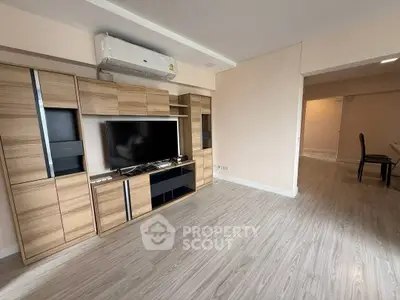Spacious living room with modern wooden entertainment unit and sleek flooring