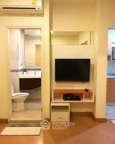 Cozy apartment interior with TV and bathroom view, ideal for modern living.
