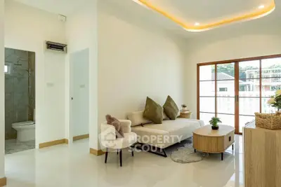 Modern living room with elegant decor and large windows offering natural light.