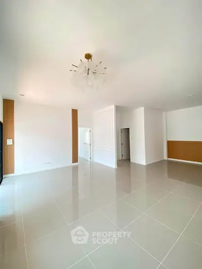Spacious modern living room with elegant chandelier and sleek tile flooring