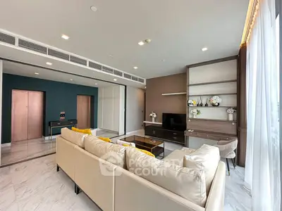 Spacious modern living room with elegant decor and large windows offering natural light.