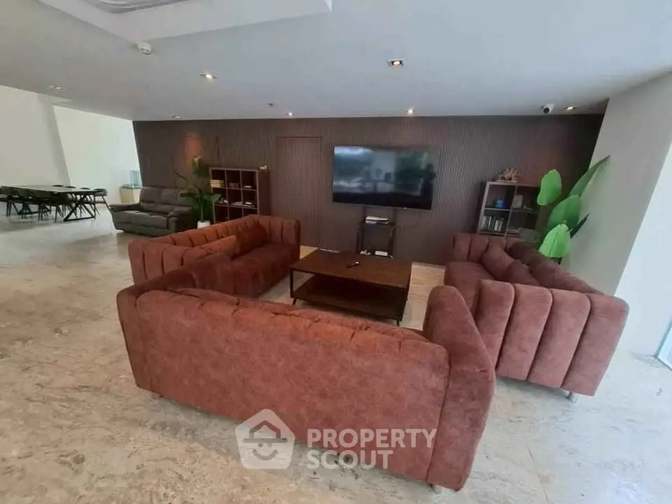 Spacious modern living room with plush sofas and large TV, perfect for relaxation and entertainment.