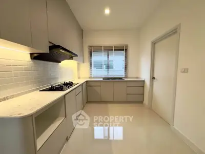 Modern kitchen with sleek cabinetry and gas stove in a bright, minimalist design.