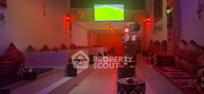 Cozy lounge area with vibrant decor and large screen for entertainment.