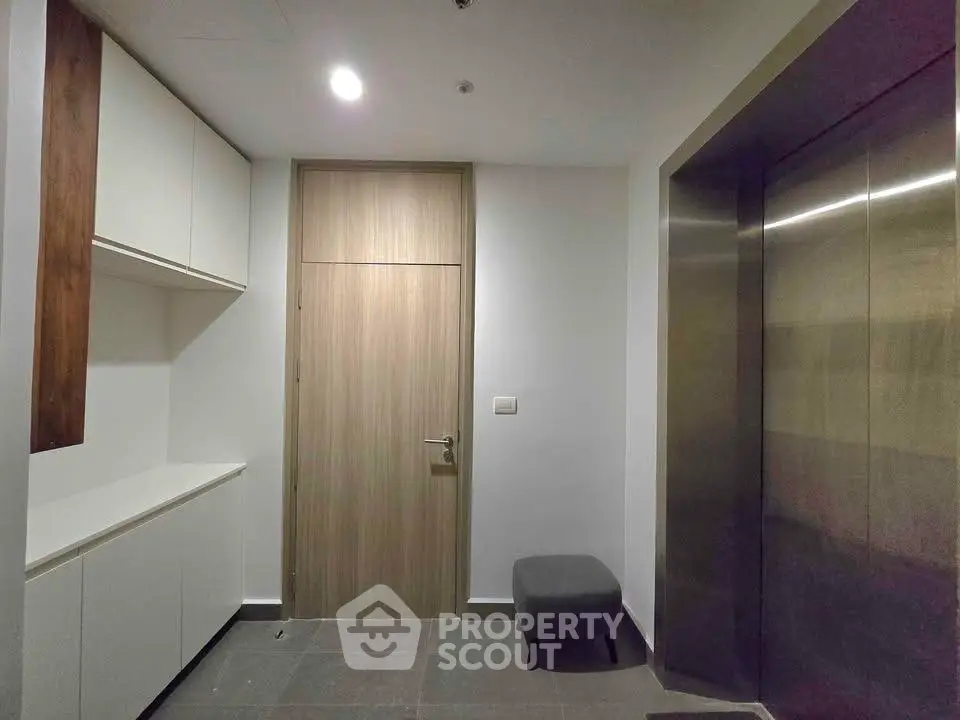 Modern apartment entrance with sleek elevator and minimalist design