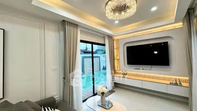 Luxurious living room with pool view, elegant chandelier, and modern entertainment setup.