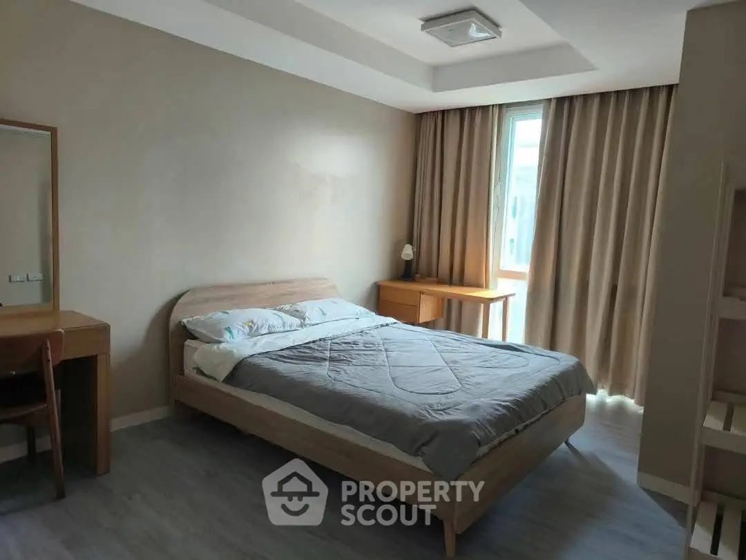 Spacious bedroom with modern furniture and natural light