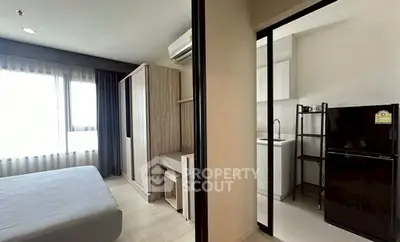 Modern apartment with bedroom and compact kitchen featuring sleek design and ample natural light.