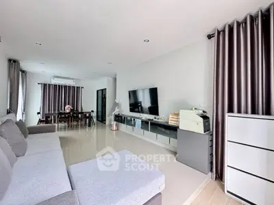 Spacious modern living room with sleek furniture and large TV, perfect for family gatherings.
