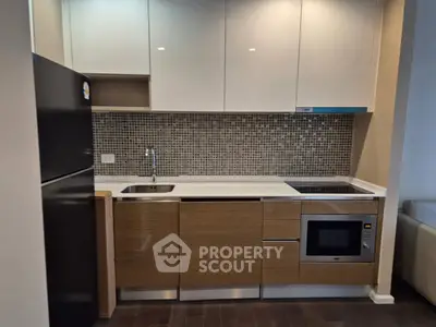 Modern kitchen with sleek cabinetry and built-in appliances in a compact layout.