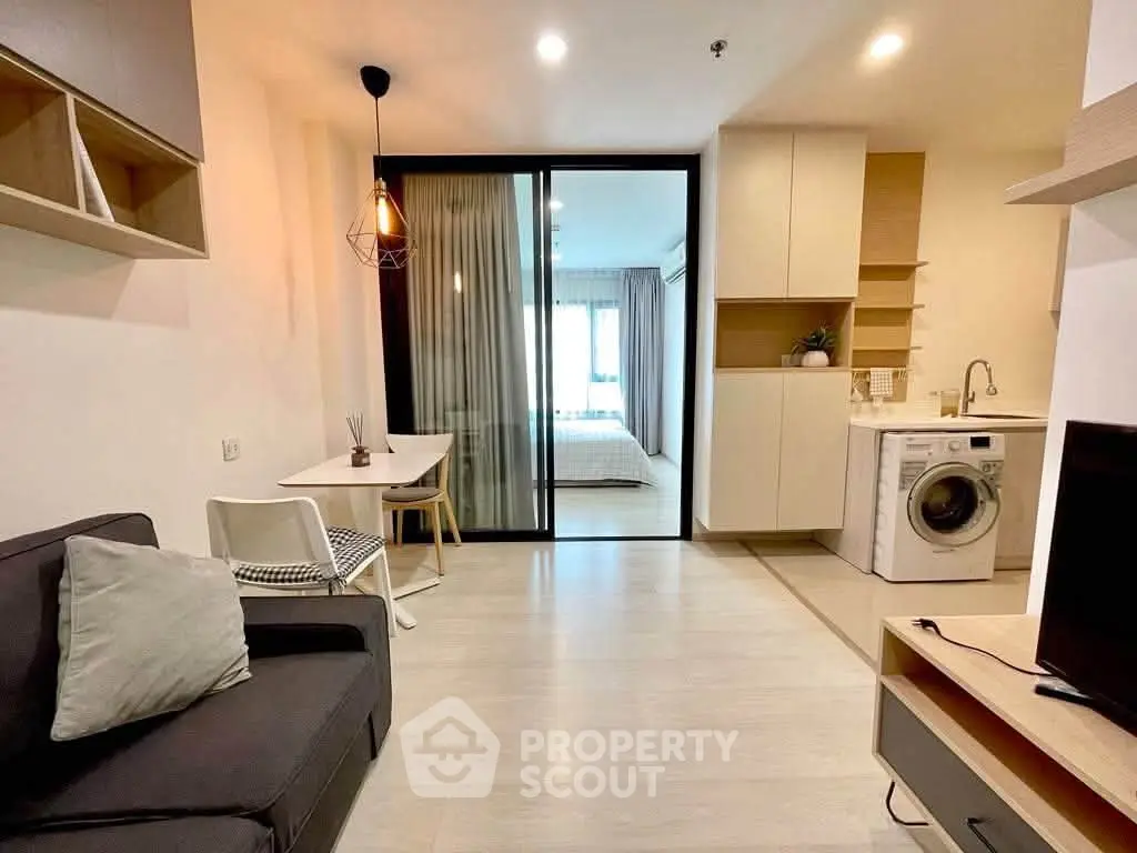 Modern open-plan living room with washing machine and cozy decor