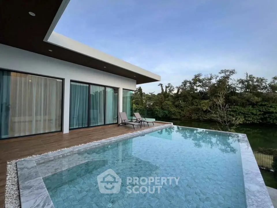 Luxurious modern home with stunning infinity pool and serene garden view.