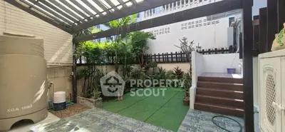 Charming outdoor garden with lush greenery and modern patio, perfect for relaxation and entertaining.