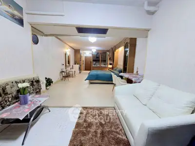 Spacious open-plan living room with modern decor and cozy seating area.