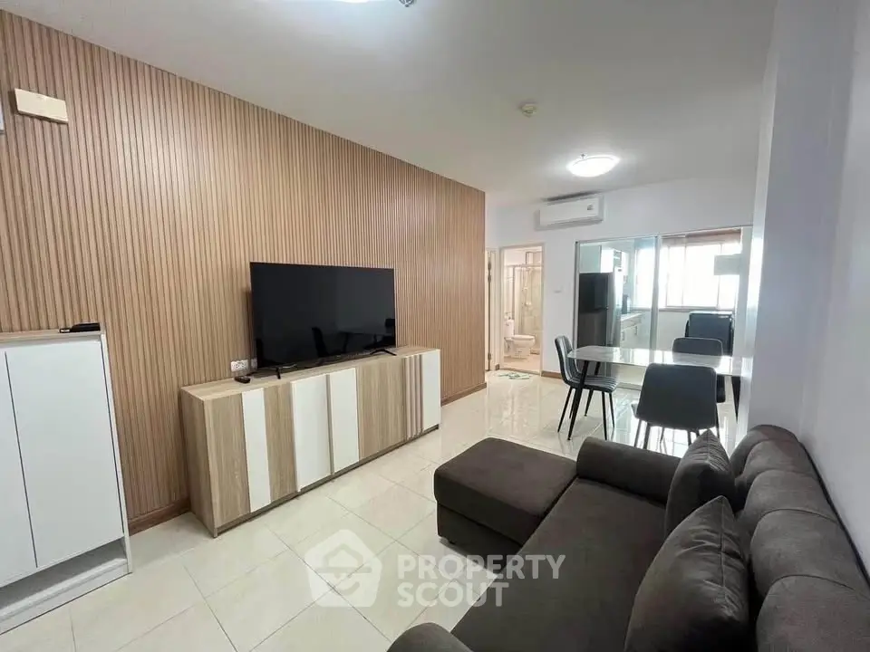 Modern living room with sleek furniture and open dining area, perfect for contemporary living.