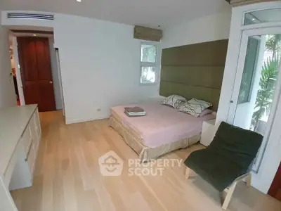 Spacious bedroom with modern decor and large windows for natural light.