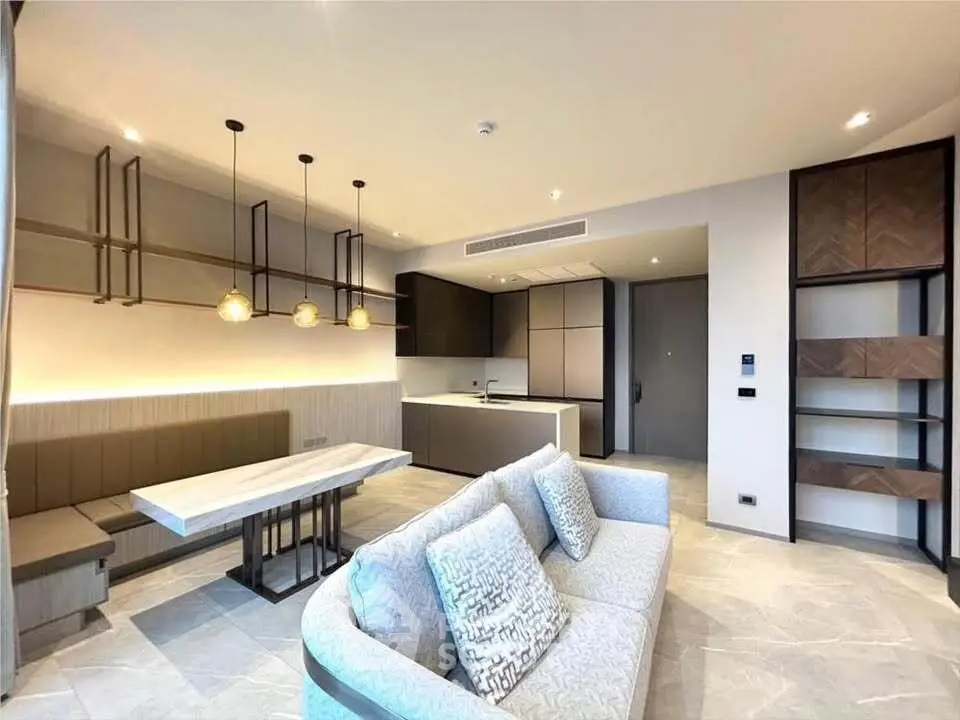 Modern open-plan living room with stylish kitchen and elegant lighting in a contemporary apartment.
