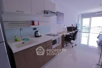 Modern kitchen with sleek cabinetry and open layout in bright apartment.