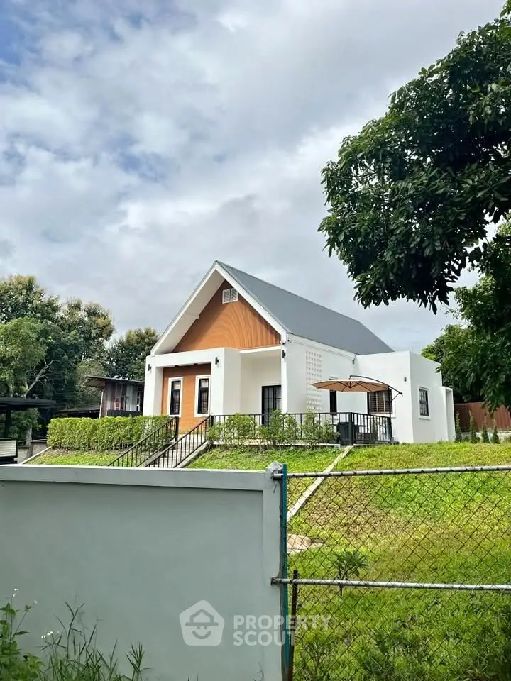 Charming modern house with lush green lawn and sleek architectural design.