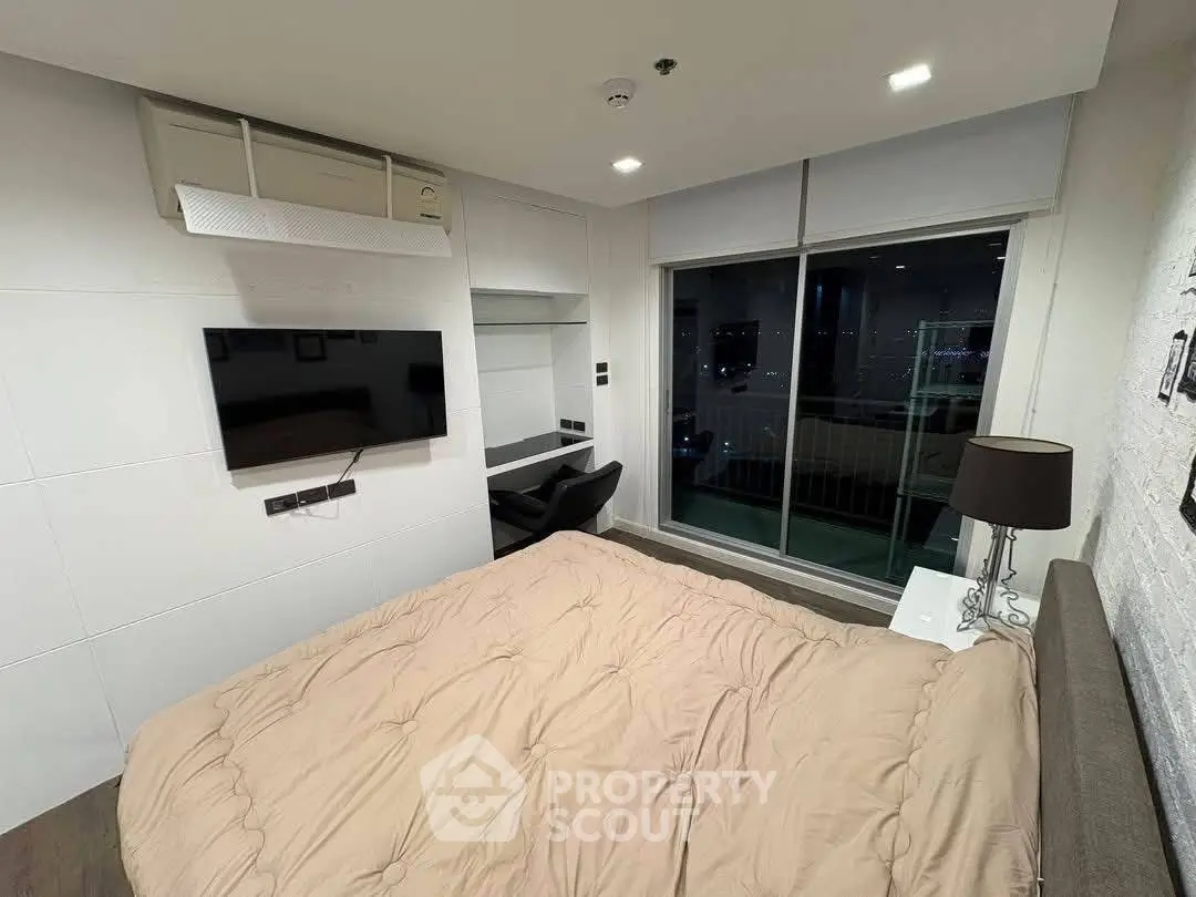 Modern bedroom with city view, featuring a wall-mounted TV and stylish decor.