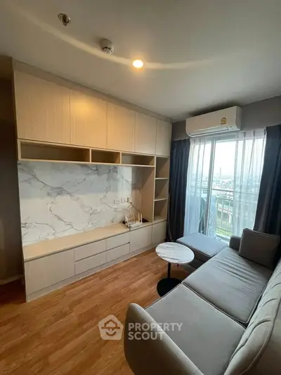 Modern living room with stylish sofa, marble accent wall, and balcony view in a cozy apartment.