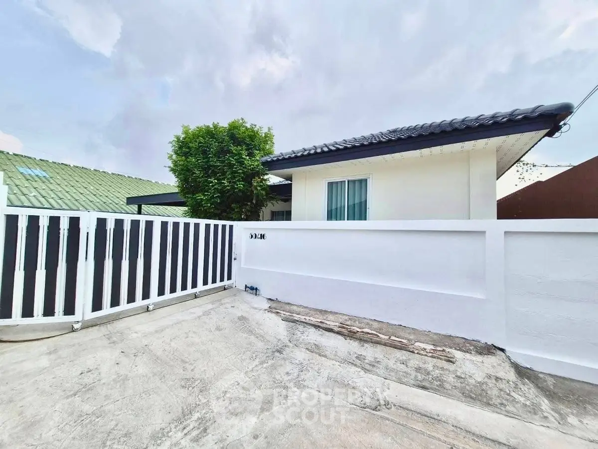 Charming single-story home with modern fence and lush greenery