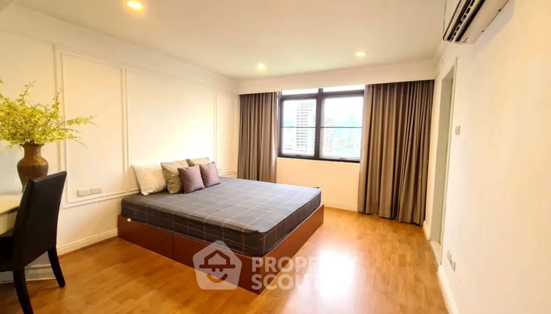 Spacious bedroom with city view and elegant decor, featuring a comfortable bed and stylish furnishings.