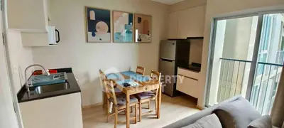 Modern apartment with compact kitchen and dining area, featuring balcony access.