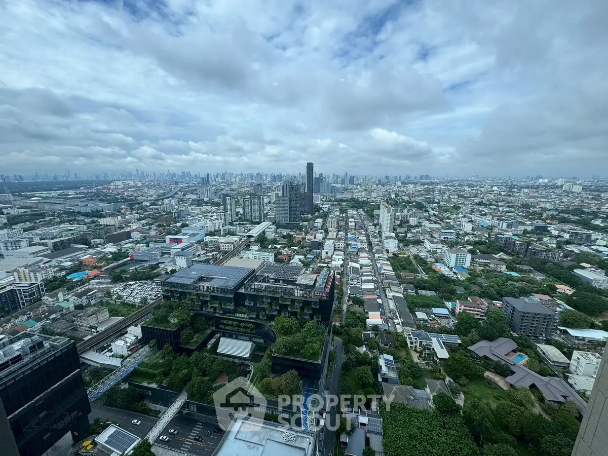 Stunning cityscape view from high-rise building showcasing urban skyline and lush greenery.