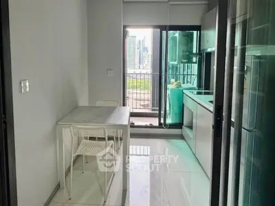 Modern kitchen with sleek design and city view from balcony, featuring open layout and dining area.