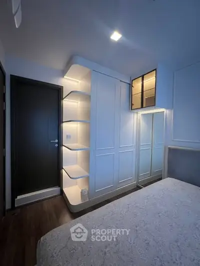 Modern bedroom with sleek built-in storage and elegant lighting