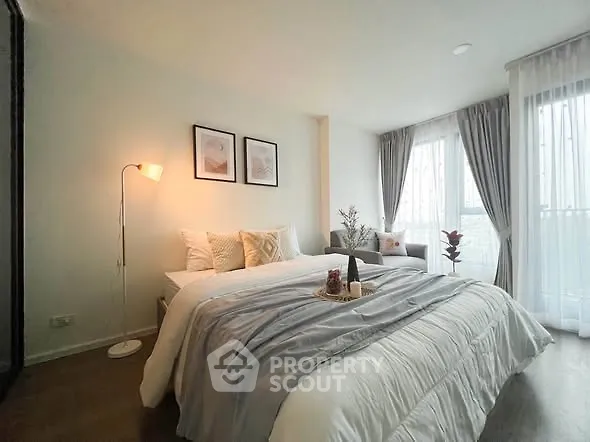 Cozy bedroom with elegant decor and large windows for natural light