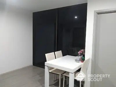 Modern dining area with sleek white table and chairs, perfect for contemporary living.