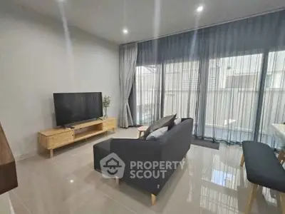 Modern living room with sleek furniture and large windows for natural light.