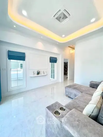 Modern living room with elegant ceiling lights and plush gray sofa