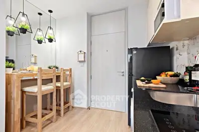 Modern kitchen with sleek black appliances and stylish wooden dining area.