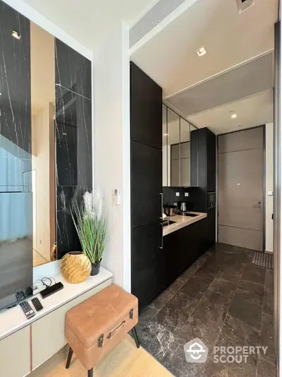 Modern kitchen with sleek black cabinetry and marble accents in luxury apartment