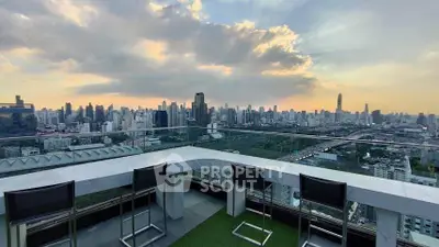 Stunning rooftop view of city skyline at sunset with modern seating area.