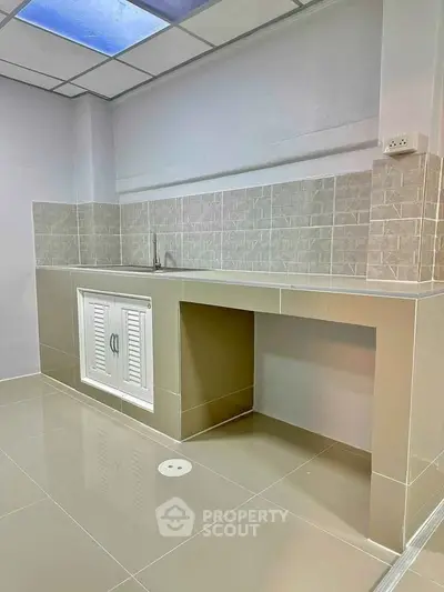 Modern minimalist kitchen with sleek tile backsplash and ample counter space.