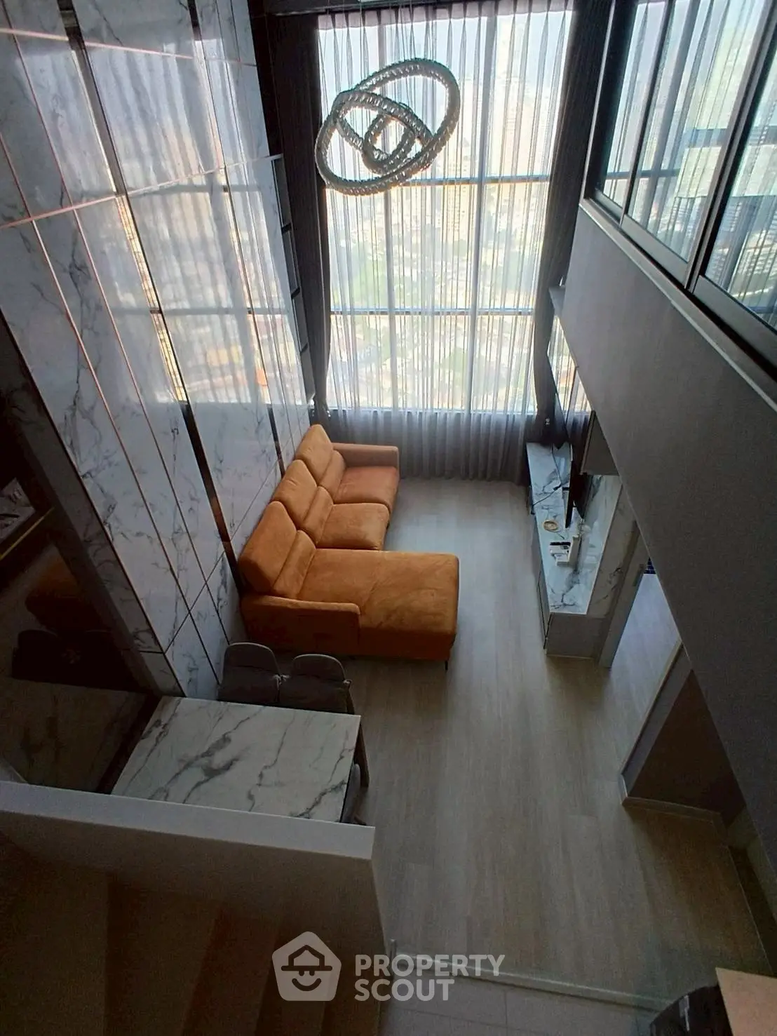 Luxurious high-ceiling living room with modern decor and large windows