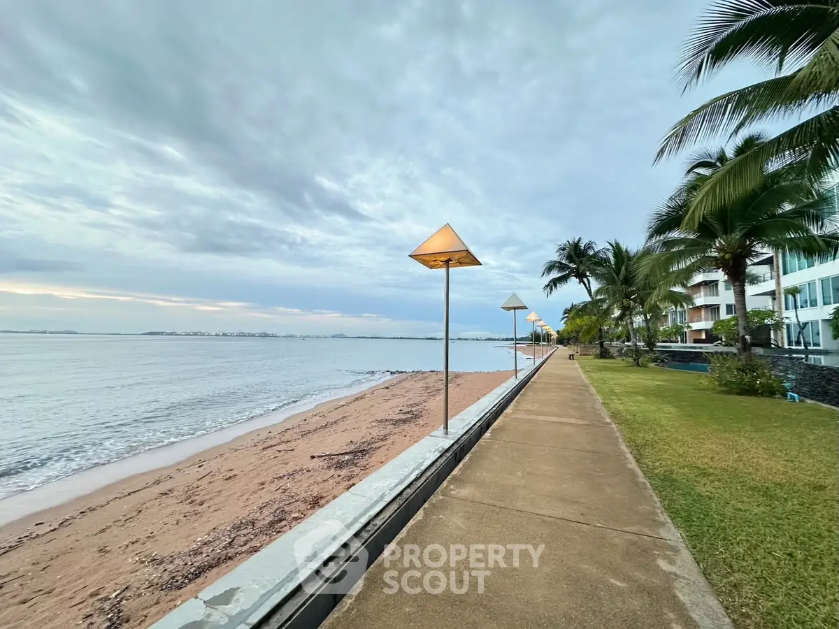 Stunning beachfront walkway with ocean view and lush greenery, perfect for serene living.